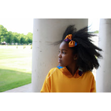 Load image into Gallery viewer, Girl with Afro hair wearing a burnt orange striped African print hair bow
